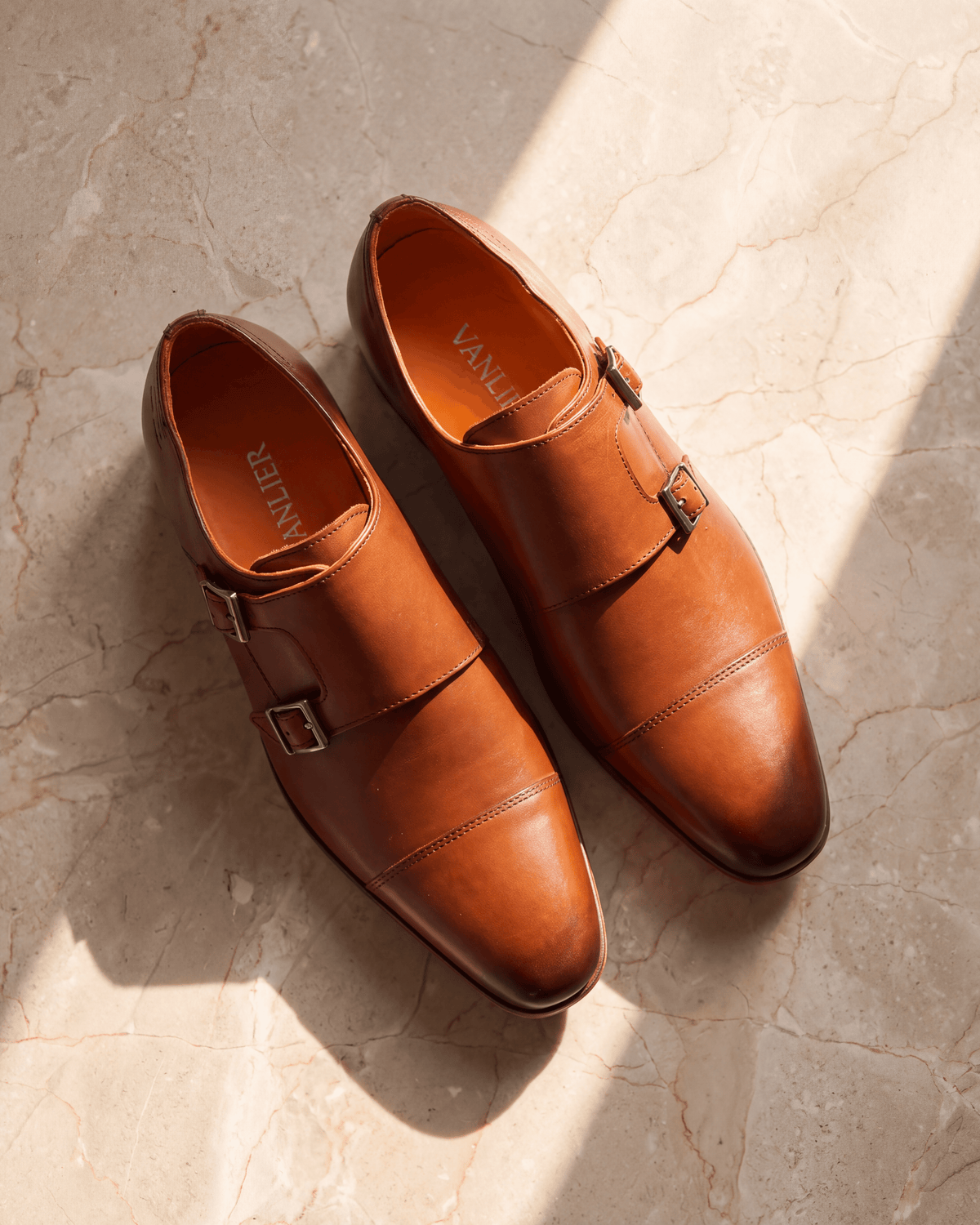 Cognac gladleren Rhodes gespschoen – het paar op warm marmer
