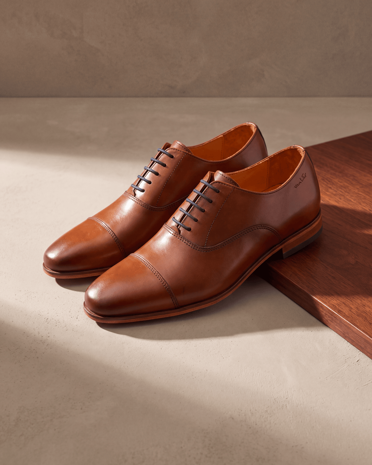 Cognac gladleren Rhodes veterschoen – het paar op hout en pleisterwerk