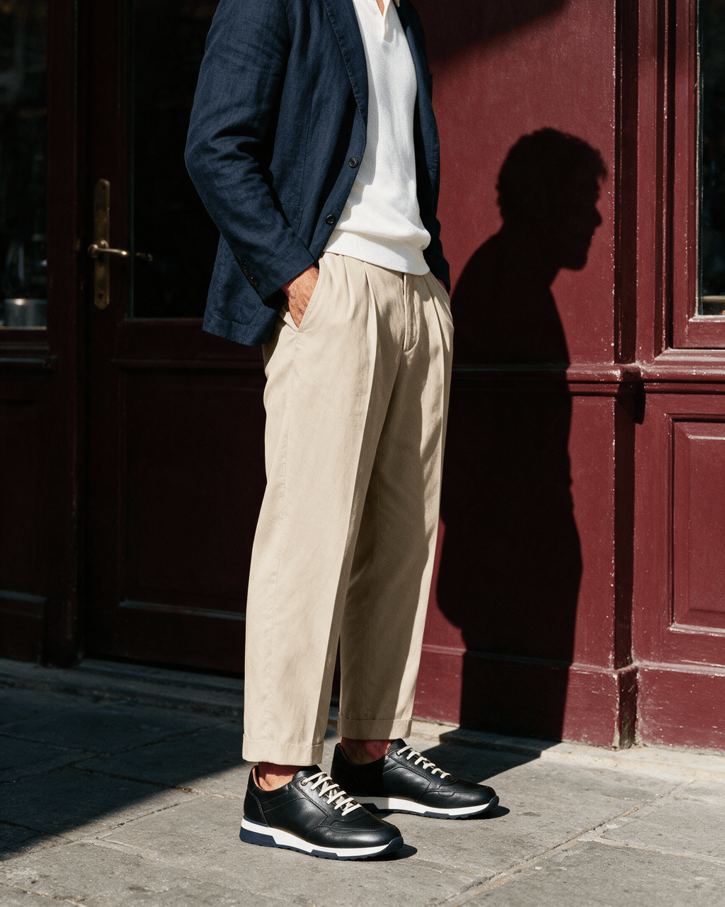 Zwart gladleren Positano sneaker – gedragen met linnen blazer en beige pantalon