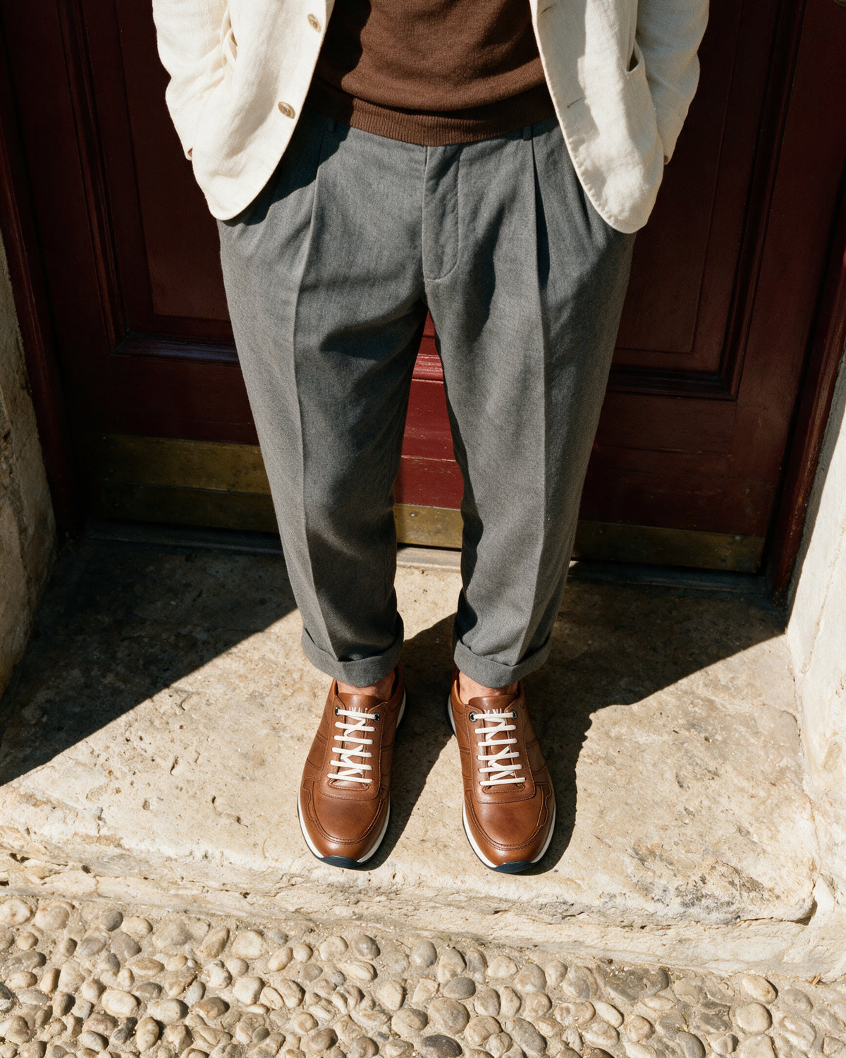 Cognac gladleren Positano sneaker – gedragen, neerkijkend op de drempel