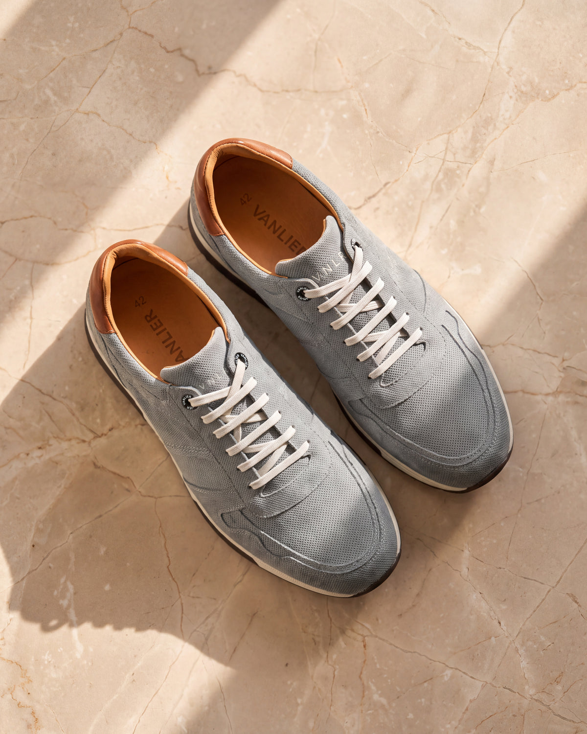 Grijs blauw suède Positano sneaker – close-up van het paar op marmer