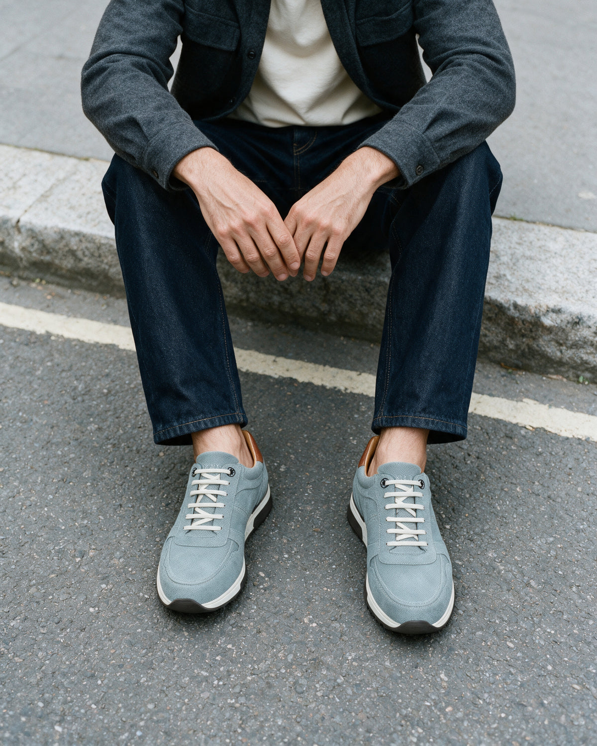 Grijs blauw suède Positano sneaker – lifestyle vanaf boven, gezeten op de stoeprand