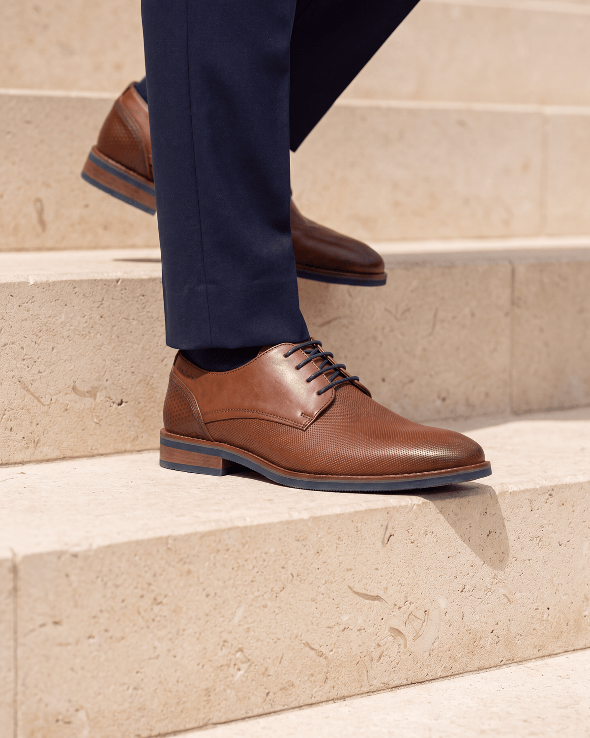 Licht cognac gladleren Amalfi veterschoen – close-up van het paar op kalksteen