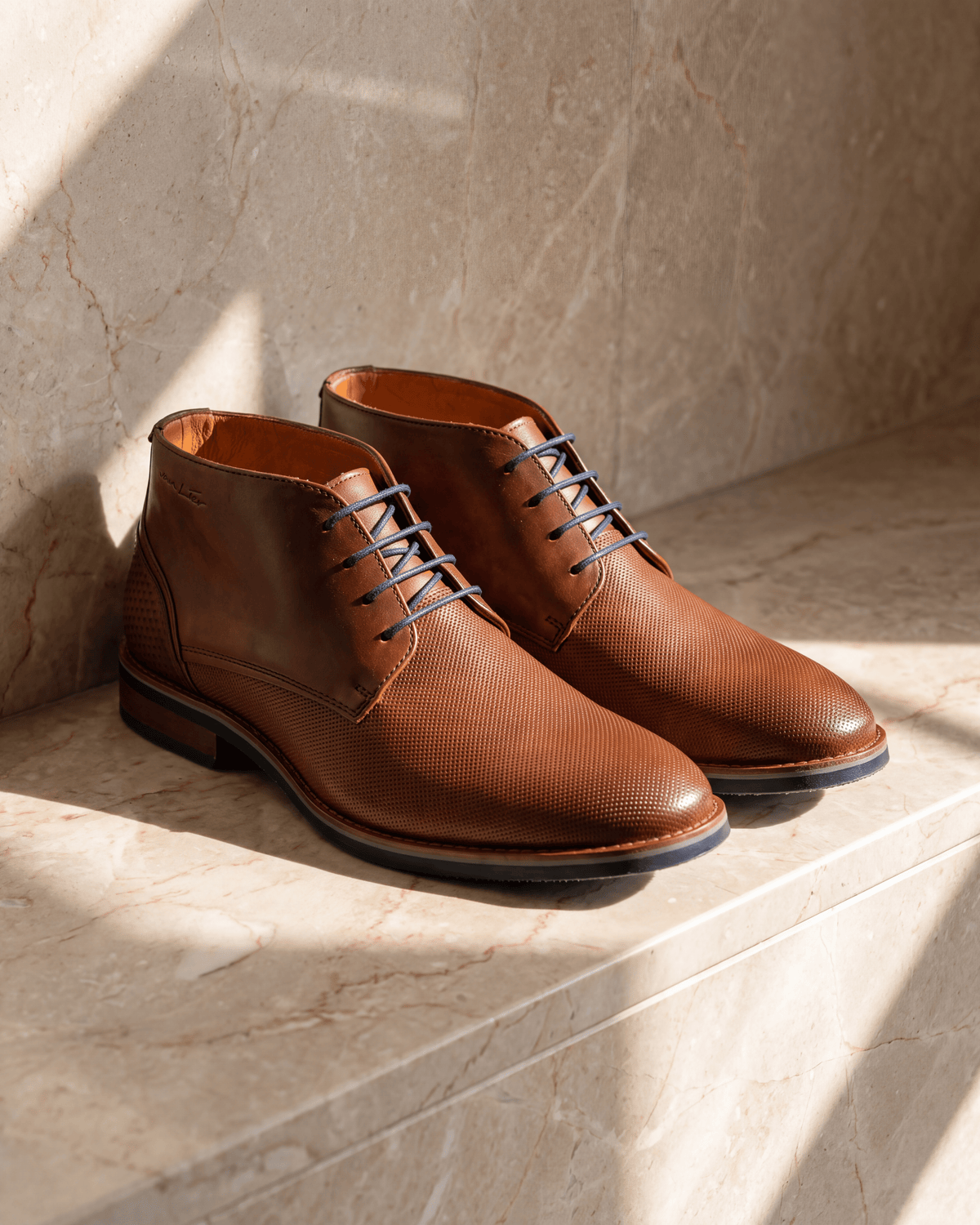 Licht cognac gladleren Amalfi halfhoge veterschoen – het paar op warm marmer