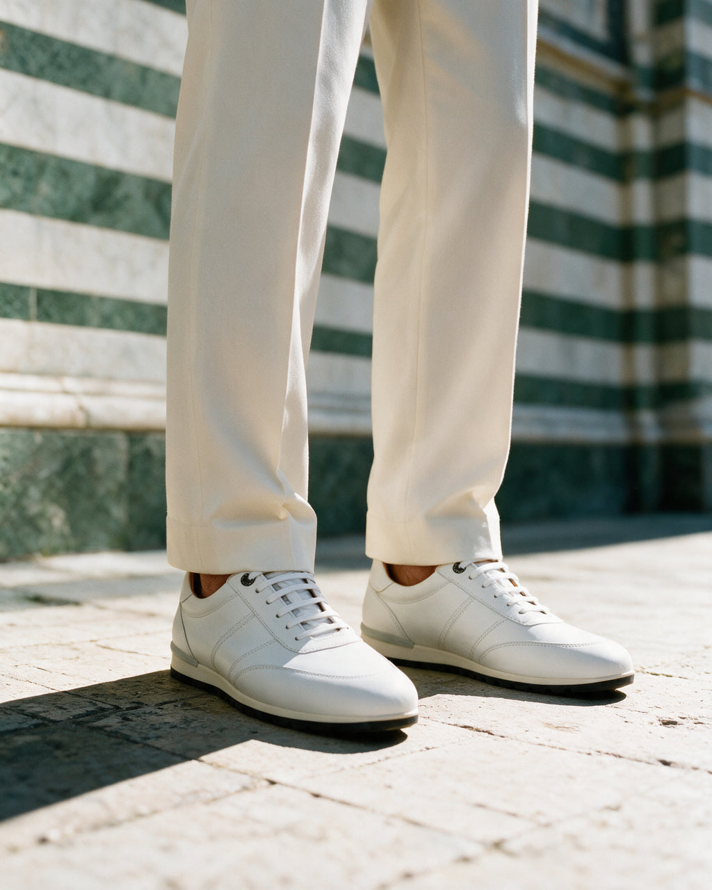 Wit gladleren Anzano sneaker – gedragen, close-up tegen gestreept marmer