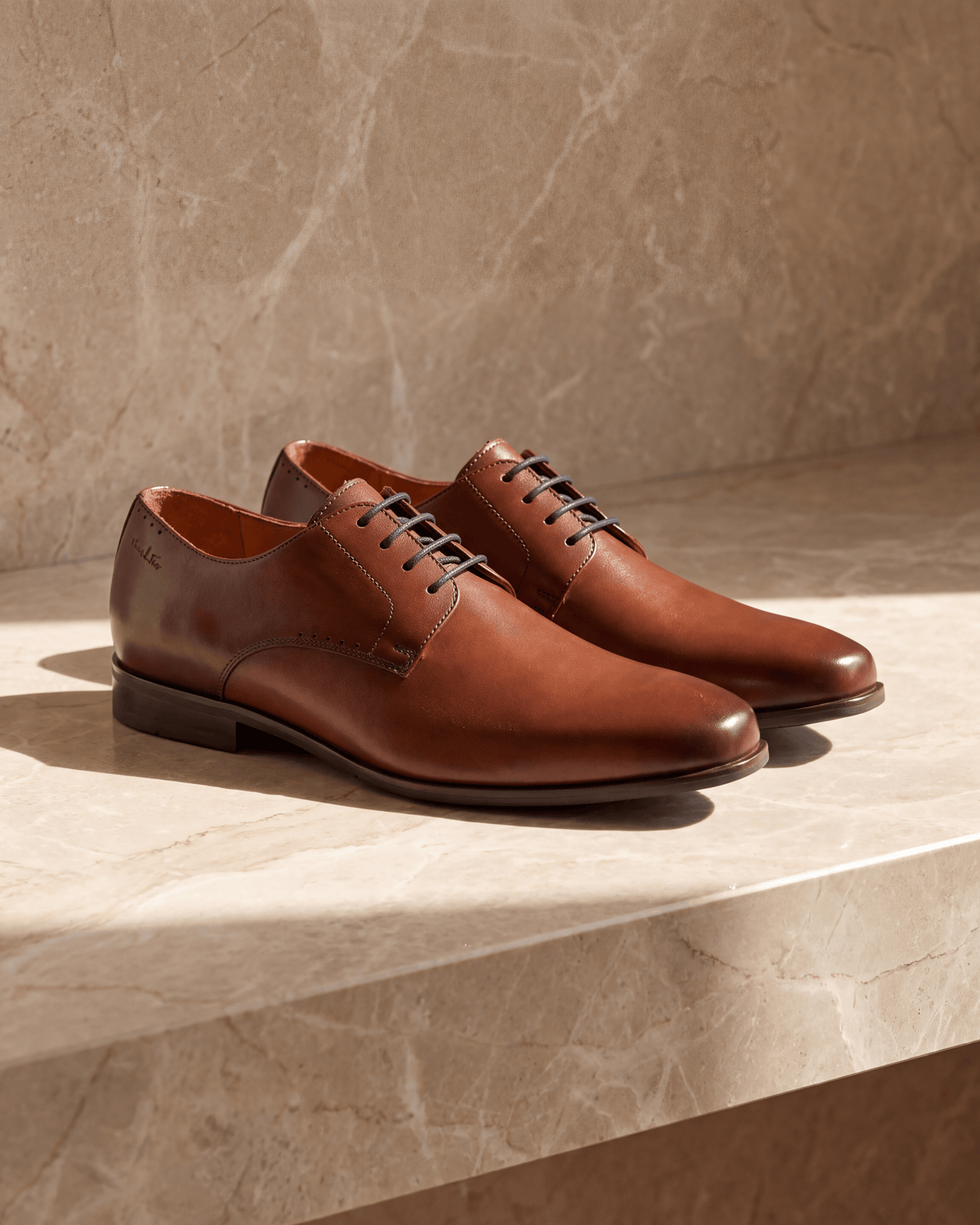 Cognac gladleren Santorini veterschoen – het paar op warm marmer