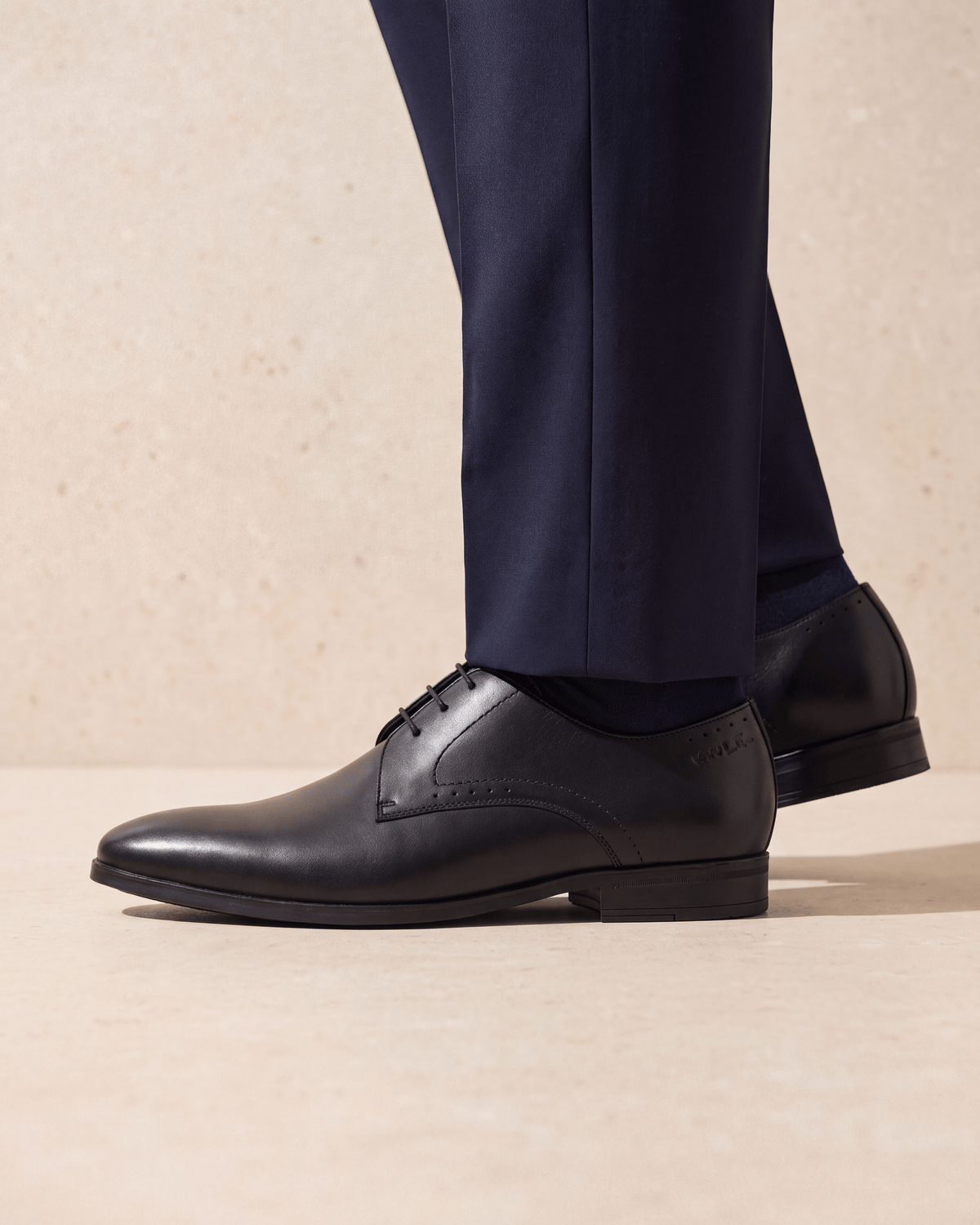 Zwart gladleren Portofino veterschoen – het paar op een kalkstenen vloer