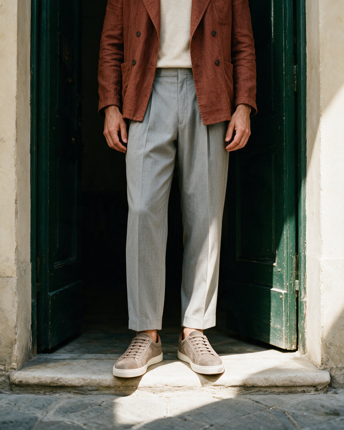 Taupe suède Napoli sneaker – lifestyle bij een groene deuropening