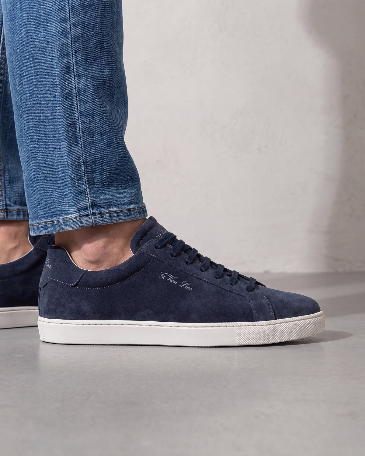 Navy blauw suède Napoli sneaker – close-up van het paar op beton in een atelier