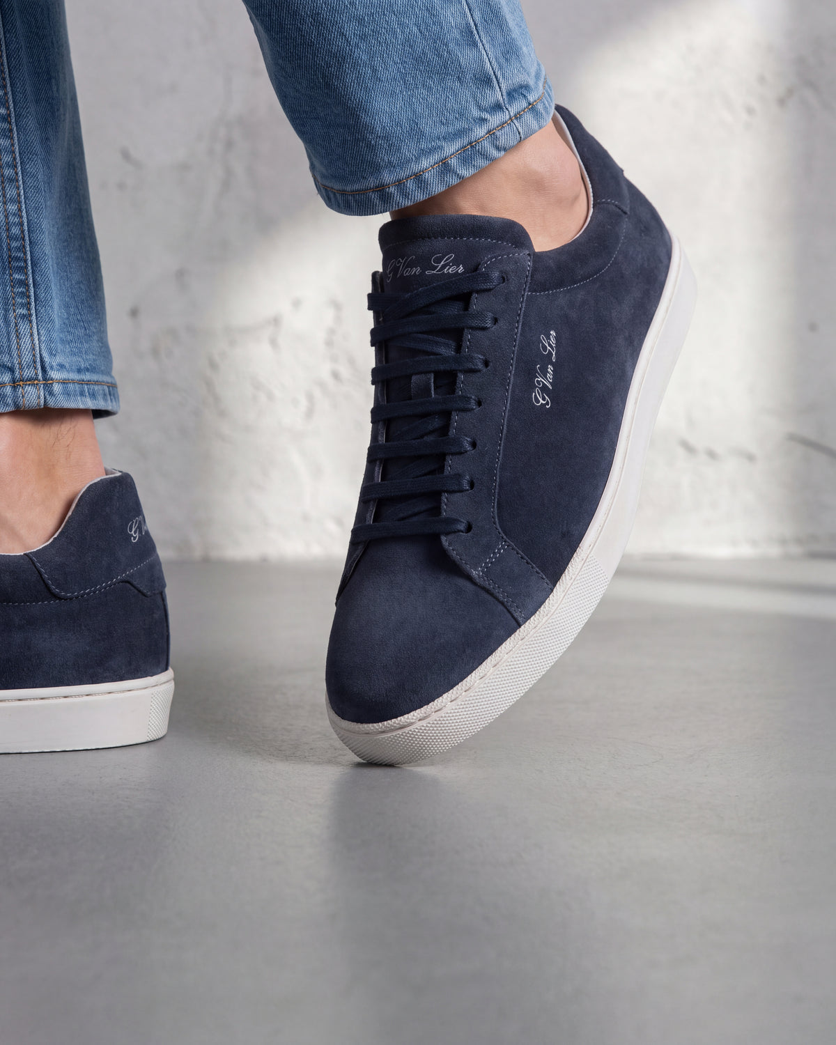 Navy blauw suède Napoli sneaker – close-up van het paar op beton, andere hoek