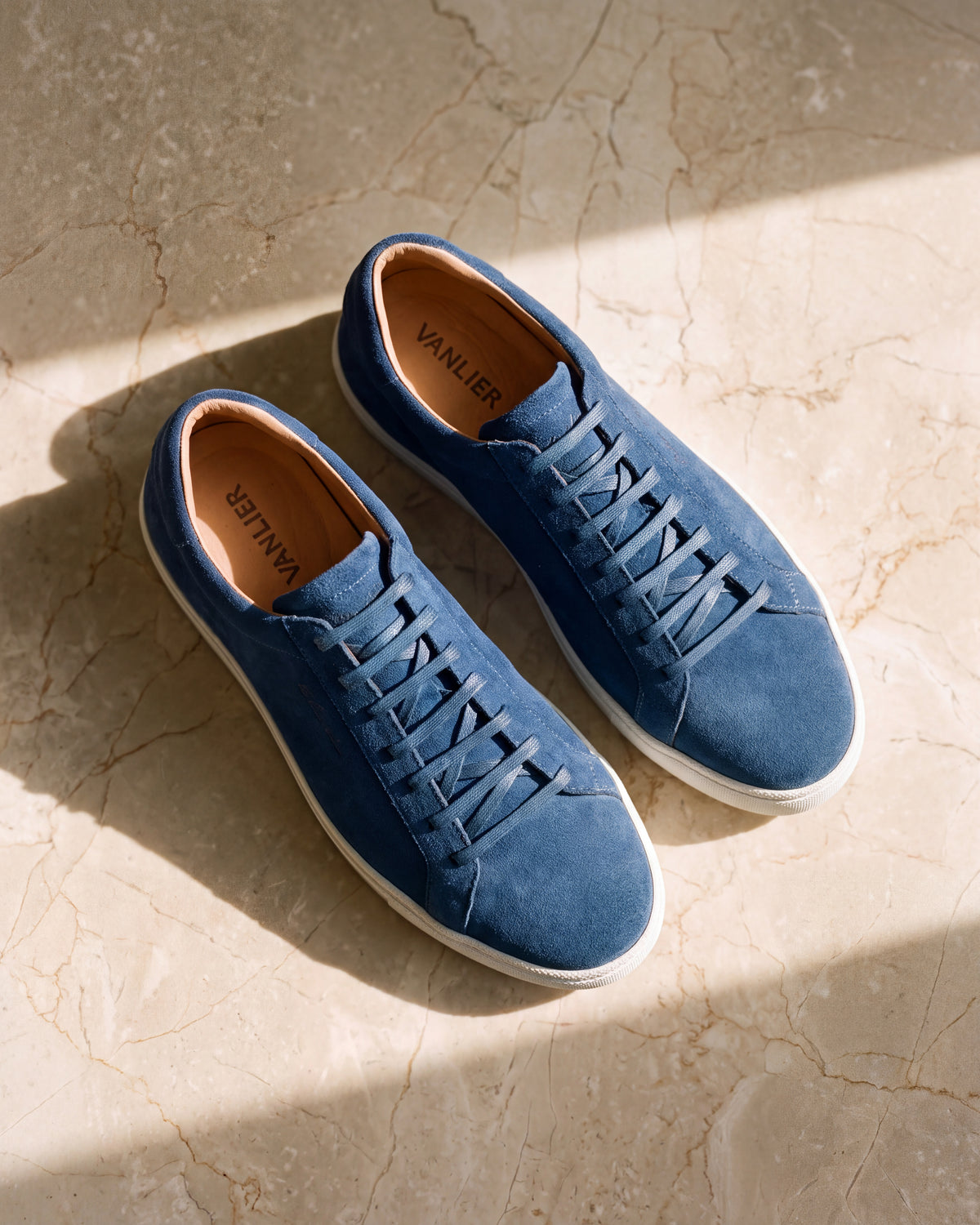 Blauw suède Napoli sneaker – detail van het paar op marmer