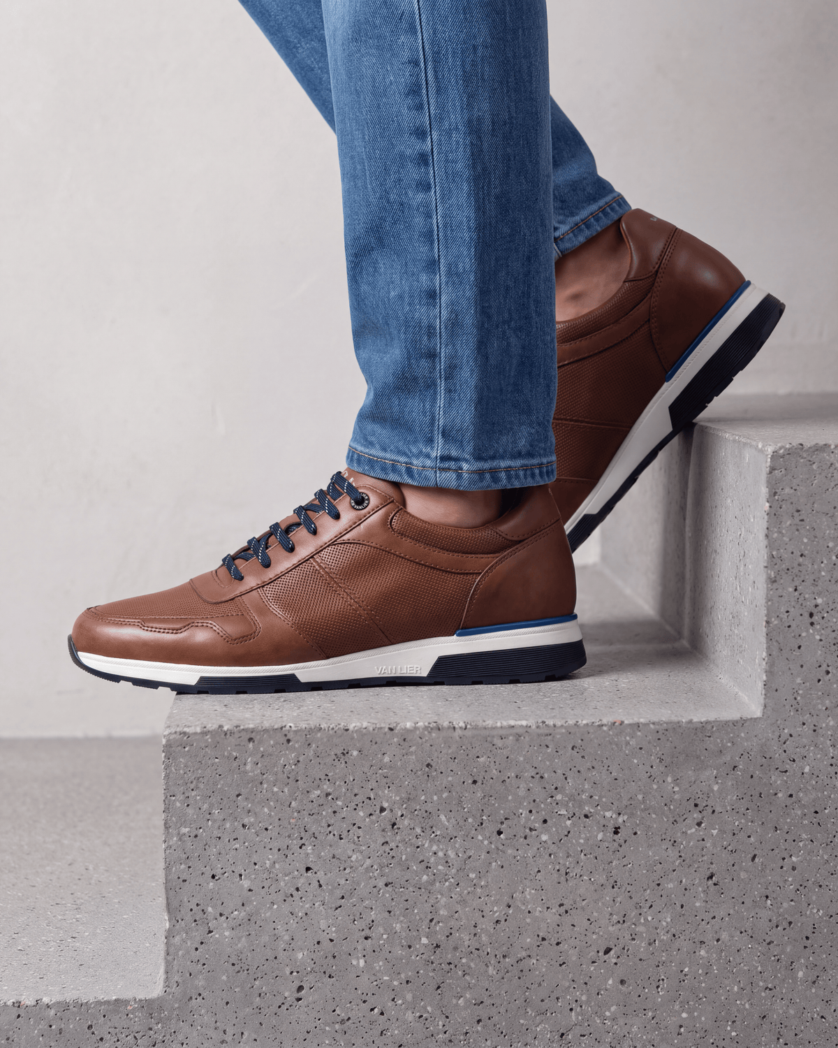 Cognac gladleren Positano sneaker – close-up van het paar op beton in een atelier
