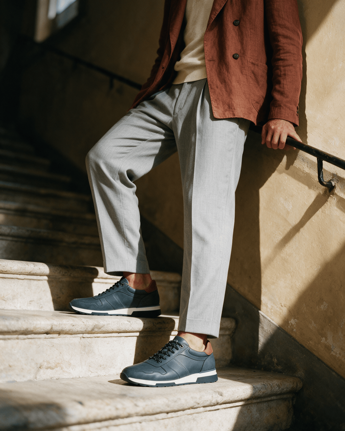 Navy blauw gladleren Positano sneaker – gedragen, pauzerend op een trap
