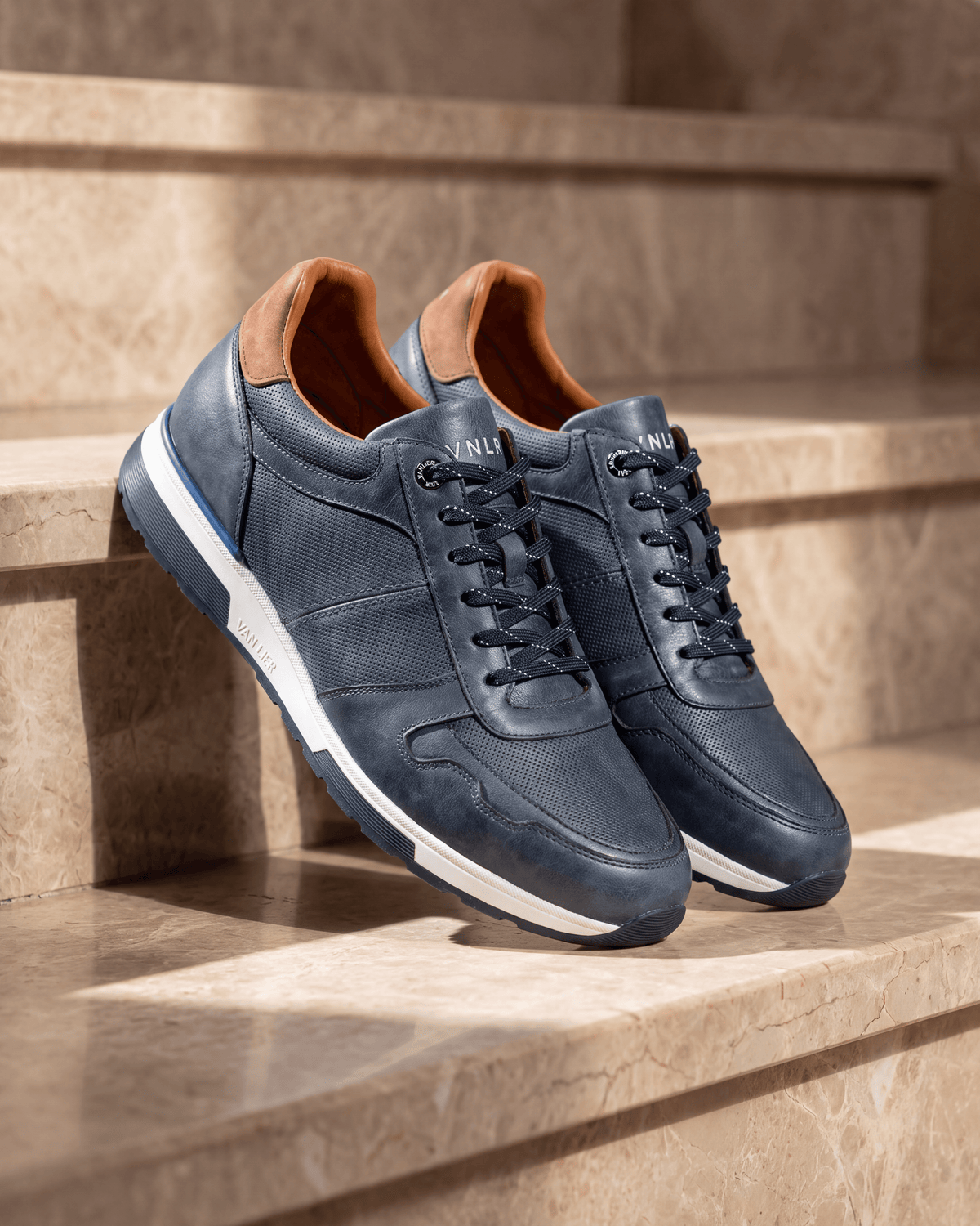 Navy blauw gladleren Positano sneaker – het paar op warm marmer