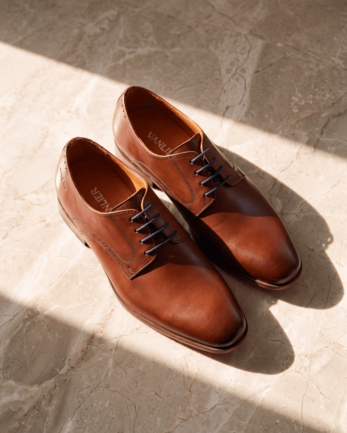Cognac gladleren Rhodes veterschoen – het paar op warm marmer