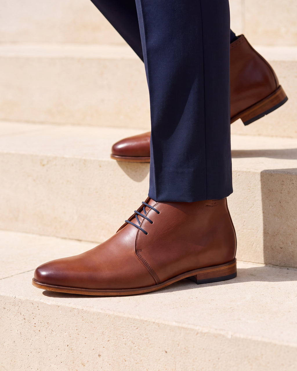 Cognac gladleren Rhodes halfhoge veterschoen – close-up van het paar op een kalkstenen vloer, andere hoek