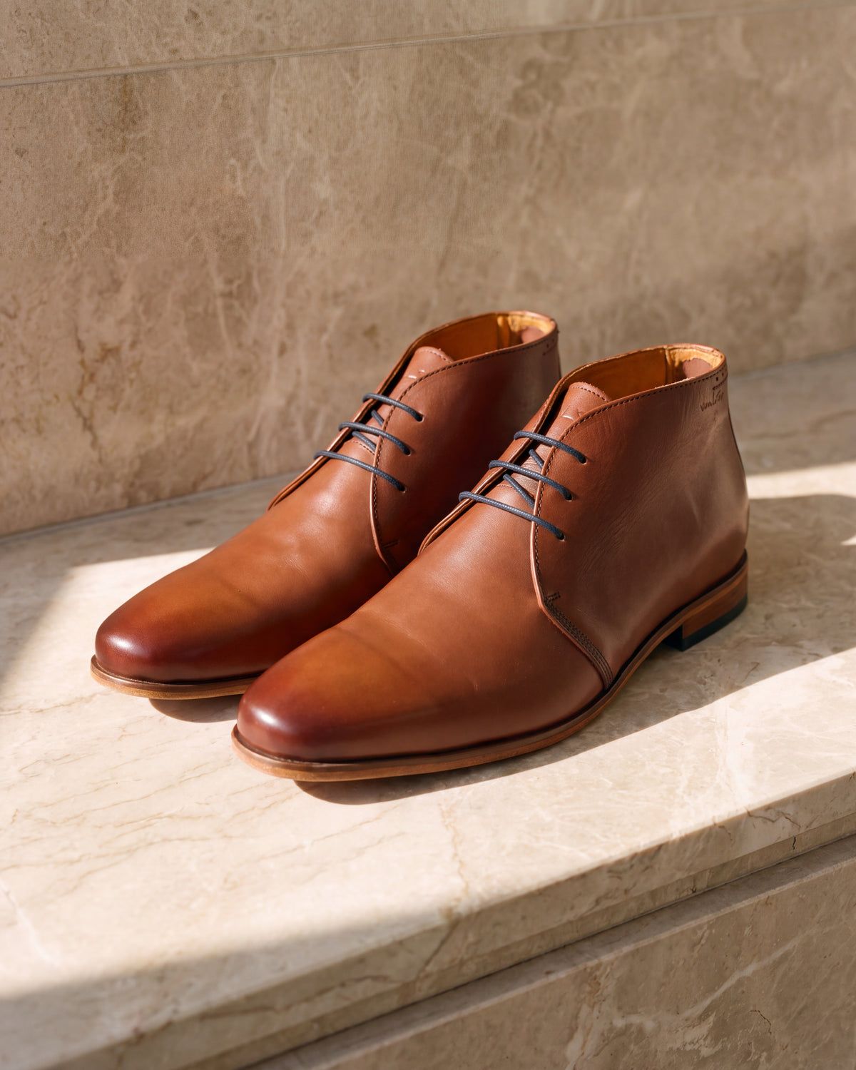 Cognac gladleren Rhodes halfhoge veterschoen – close-up van het paar op marmer