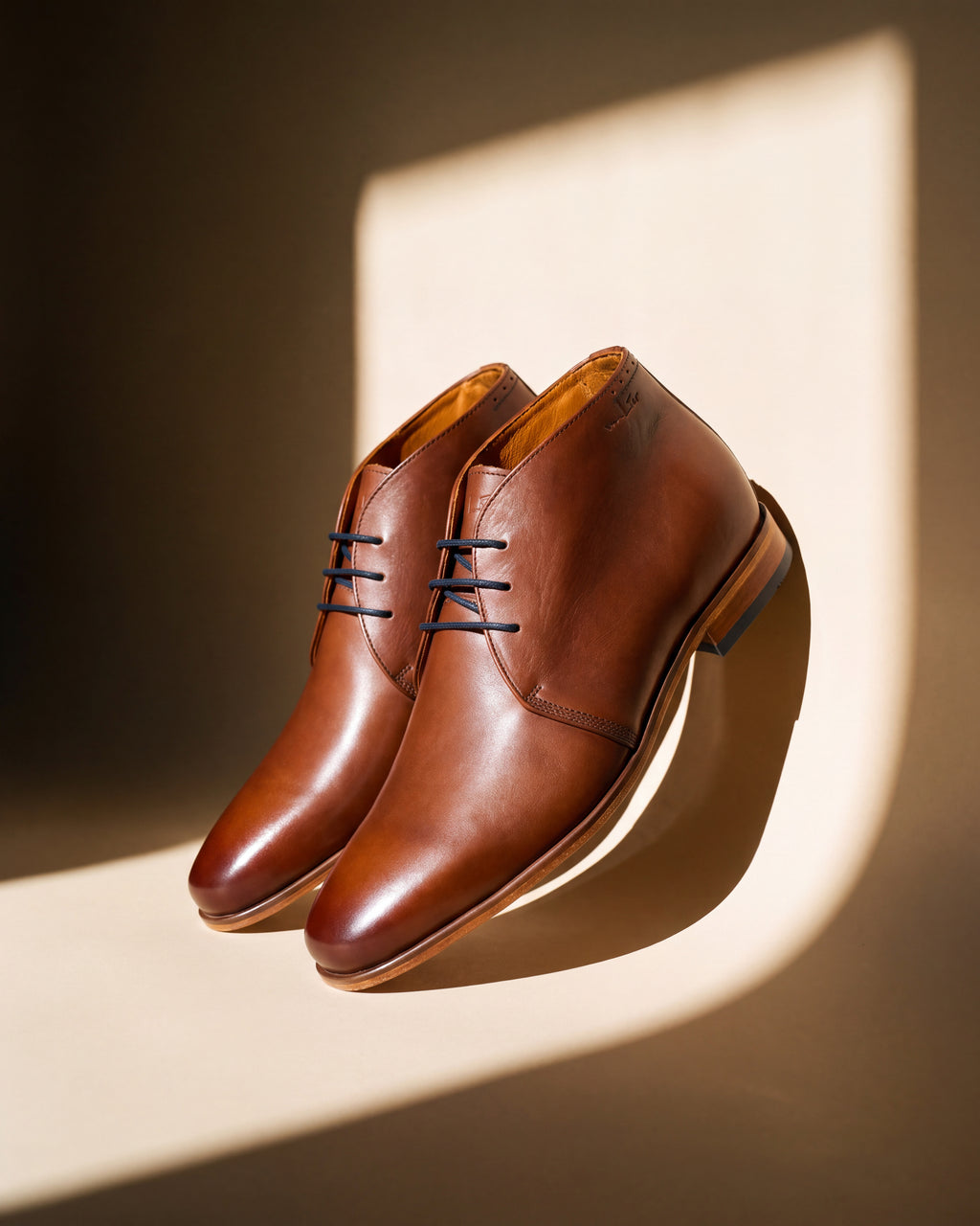 Cognac gladleren Rhodes halfhoge veterschoen – detail van het paar met raamschaduw