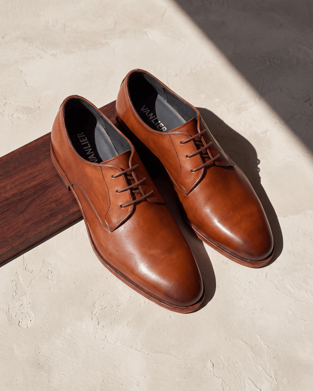 Cognac gladleren Madison veterschoen – het paar op hout en pleisterwerk