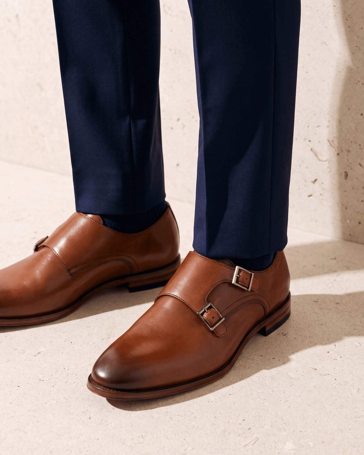 Cognac gladleren Madison gespschoen – close-up van het paar op kalksteen