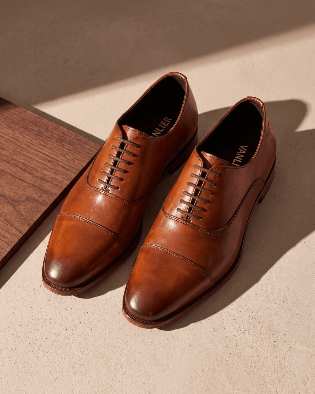Cognac gladleren Madison veterschoen – het paar op hout en pleisterwerk