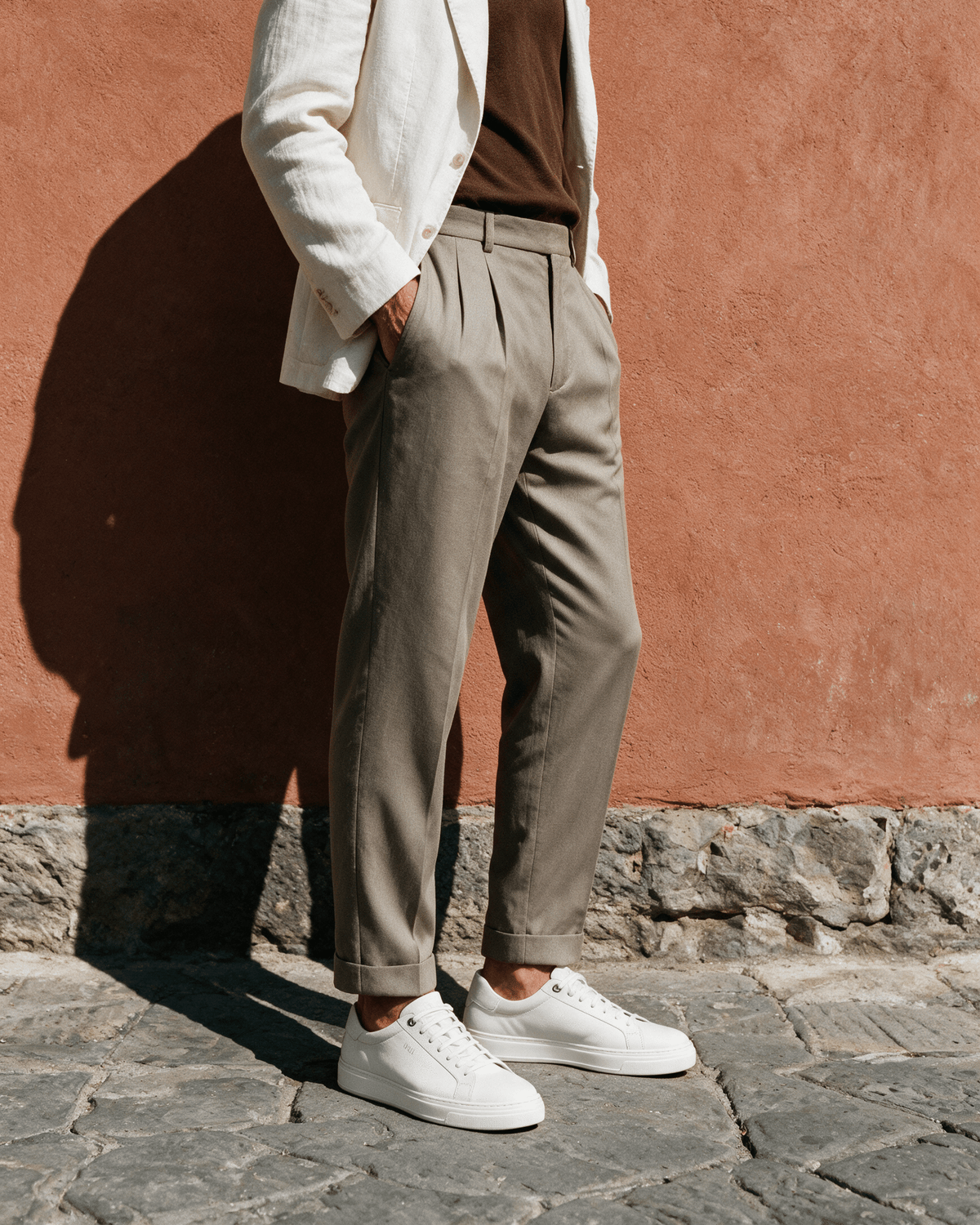 Wit gladleren Barossa sneaker – gedragen, in profiel tegen een terracotta muur