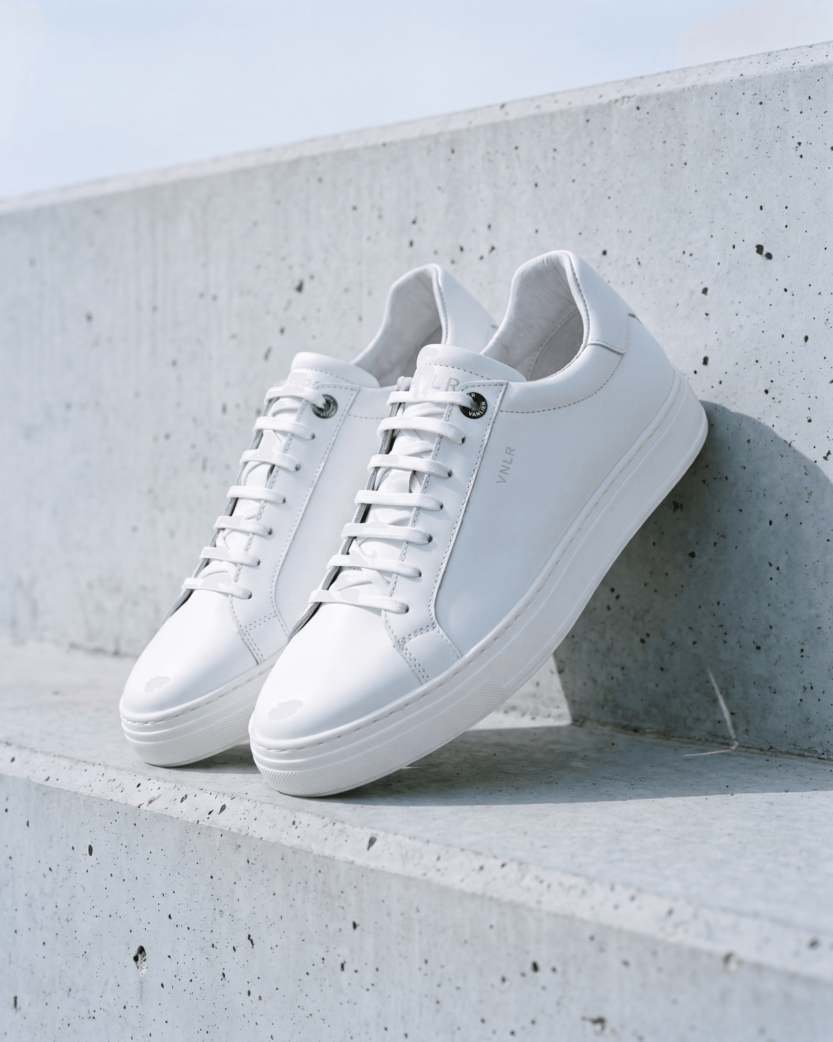 Wit gladleren Barossa sneaker – het paar op ruw beton