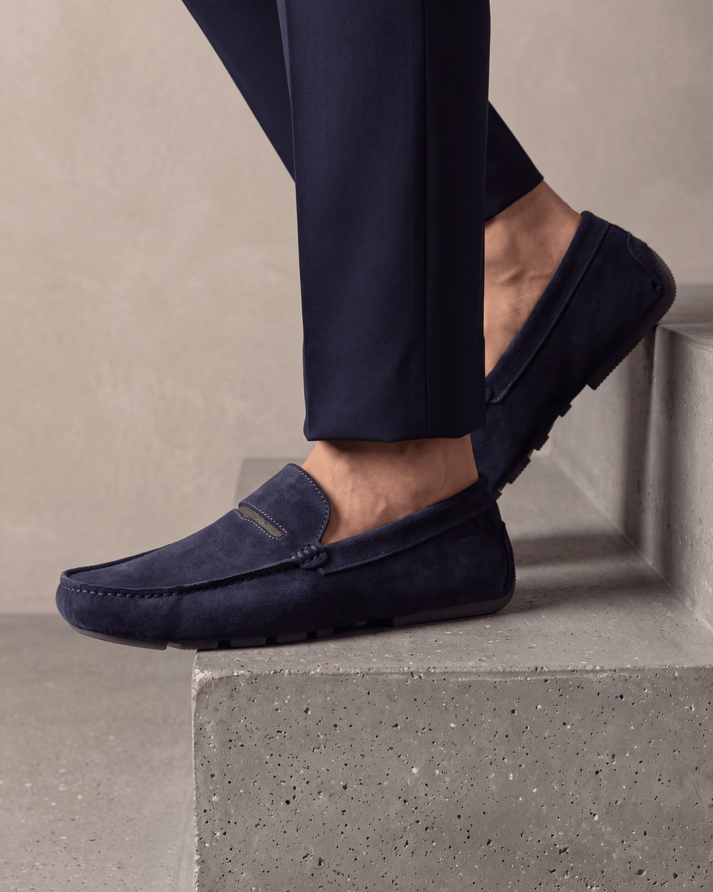 Navy blauw suède Mocassin – close-up van het paar op beton