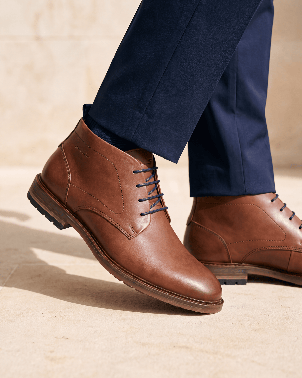 Cognac gladleren Dino Boot – het paar op een kalkstenen vloer