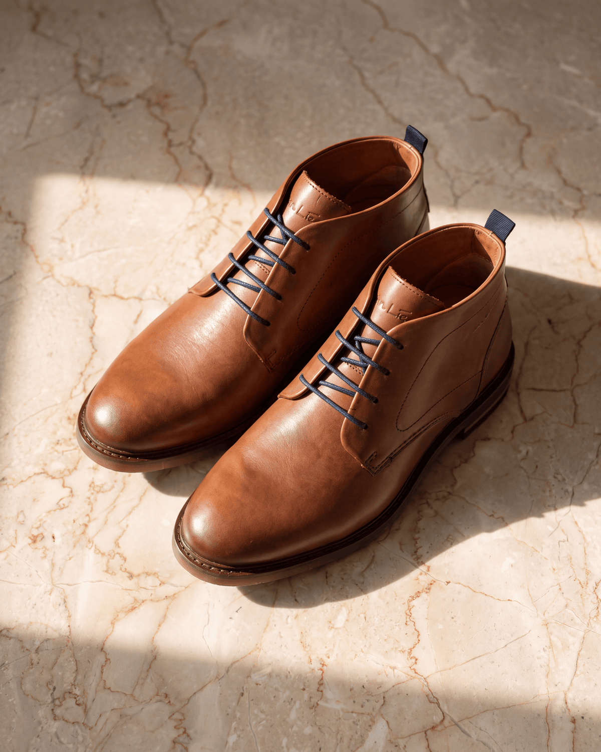 Cognac gladleren Dino Boot – detail op warm marmer