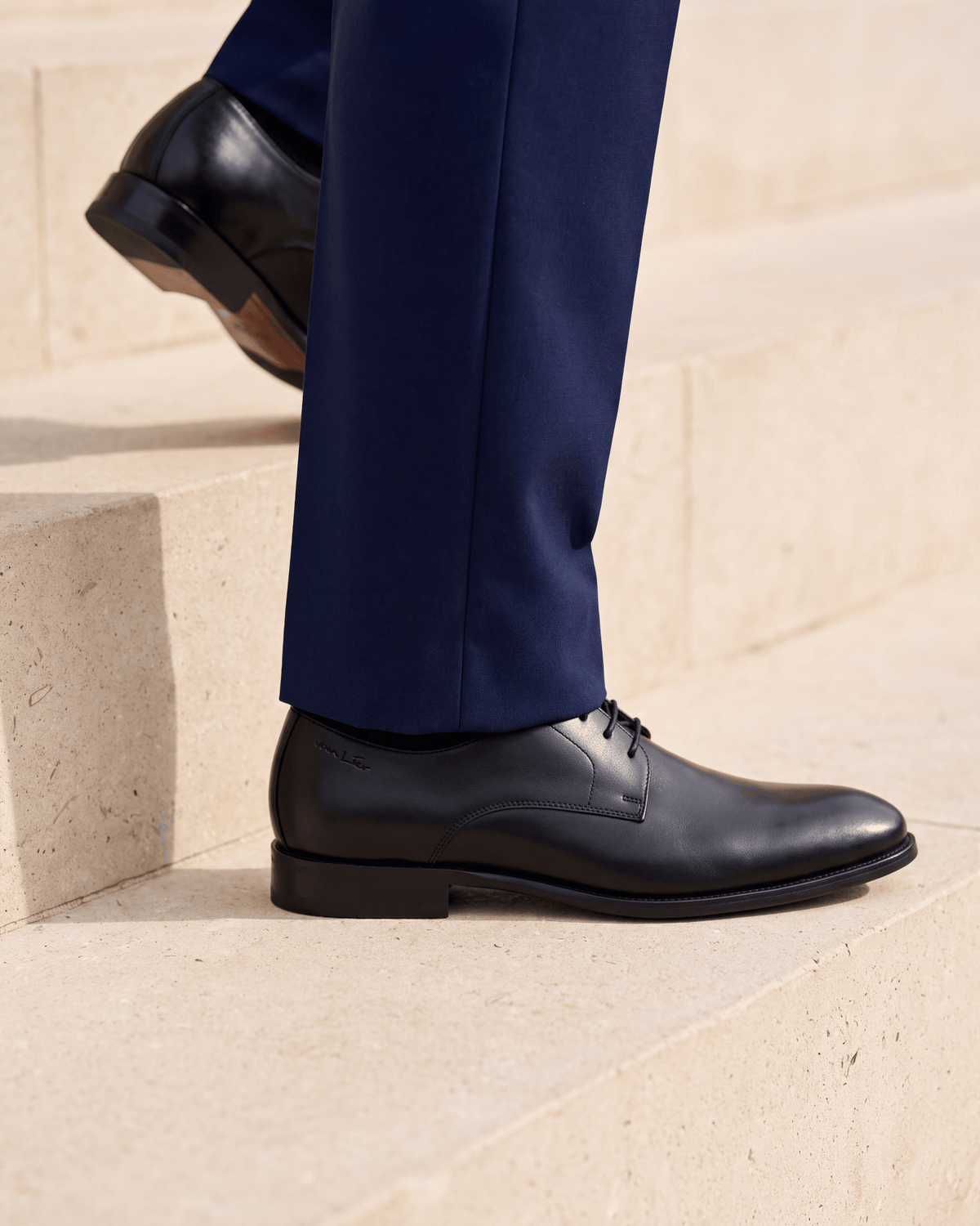 Zwart gladleren met rubberen zool Rhodes veterschoen – close-up van het paar op kalksteen