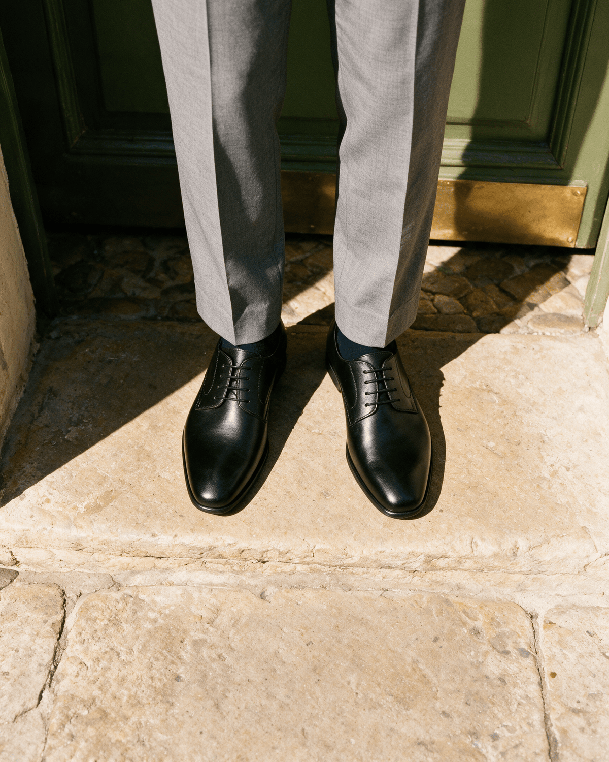 Zwart gladleren met rubberen zool Rhodes veterschoen – gedragen, op een drempel, van boven gezien