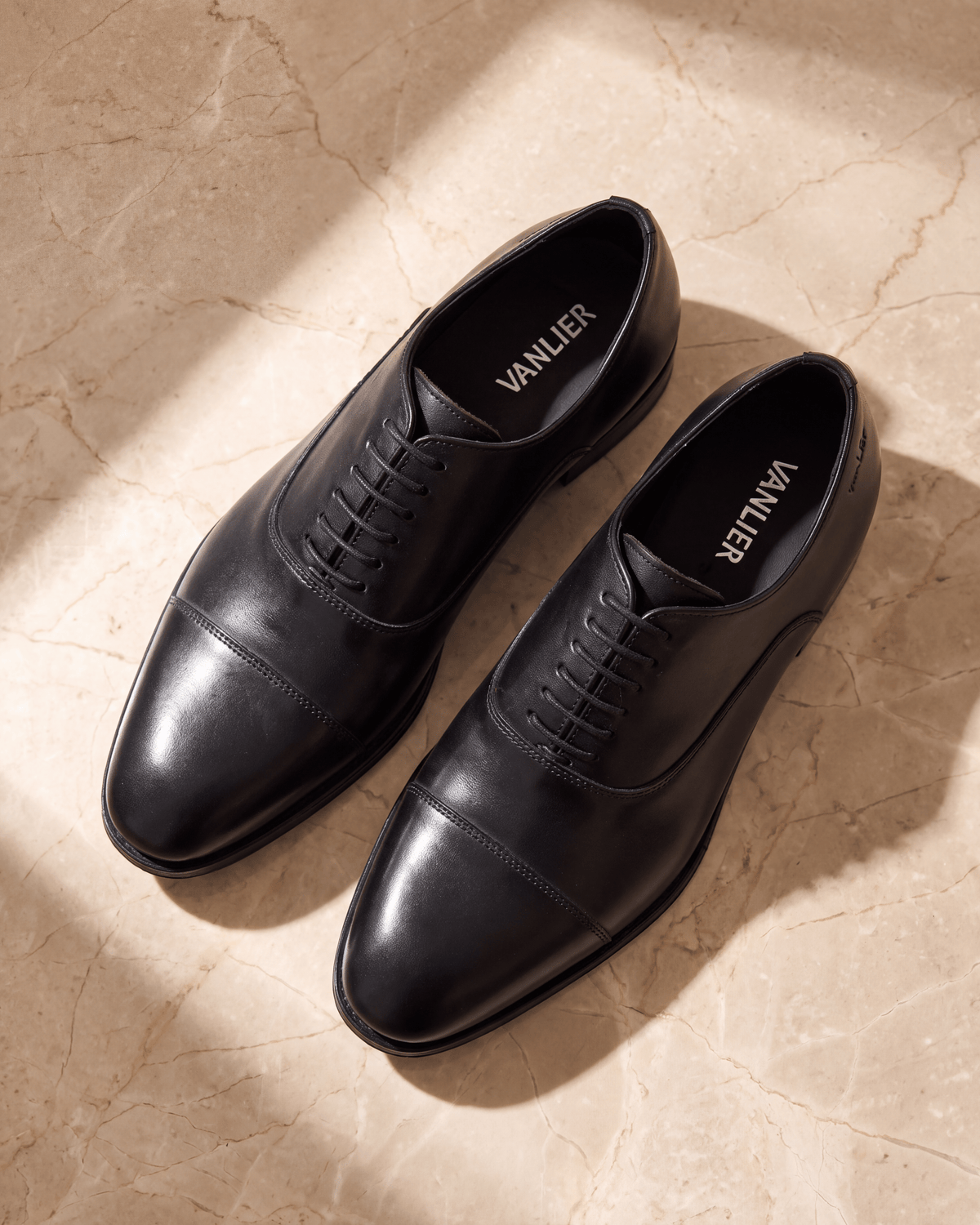 Zwart gladleren Madison veterschoen – detail op warm marmer