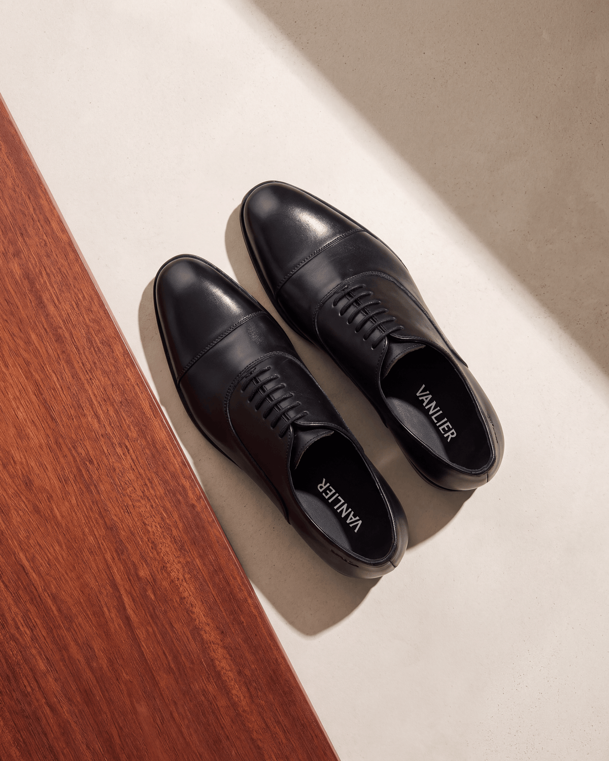 Zwart gladleren Madison veterschoen – het paar op hout en pleisterwerk
