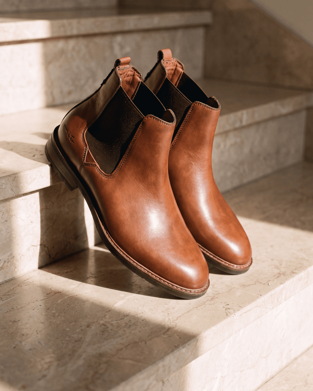 Cognac gladleren Boston chelsea boot – detail op warm marmer