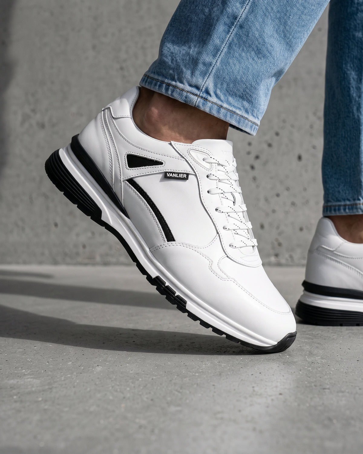 Wit gladleren Veneto sneaker – close-up van het paar op een betonnen vloer