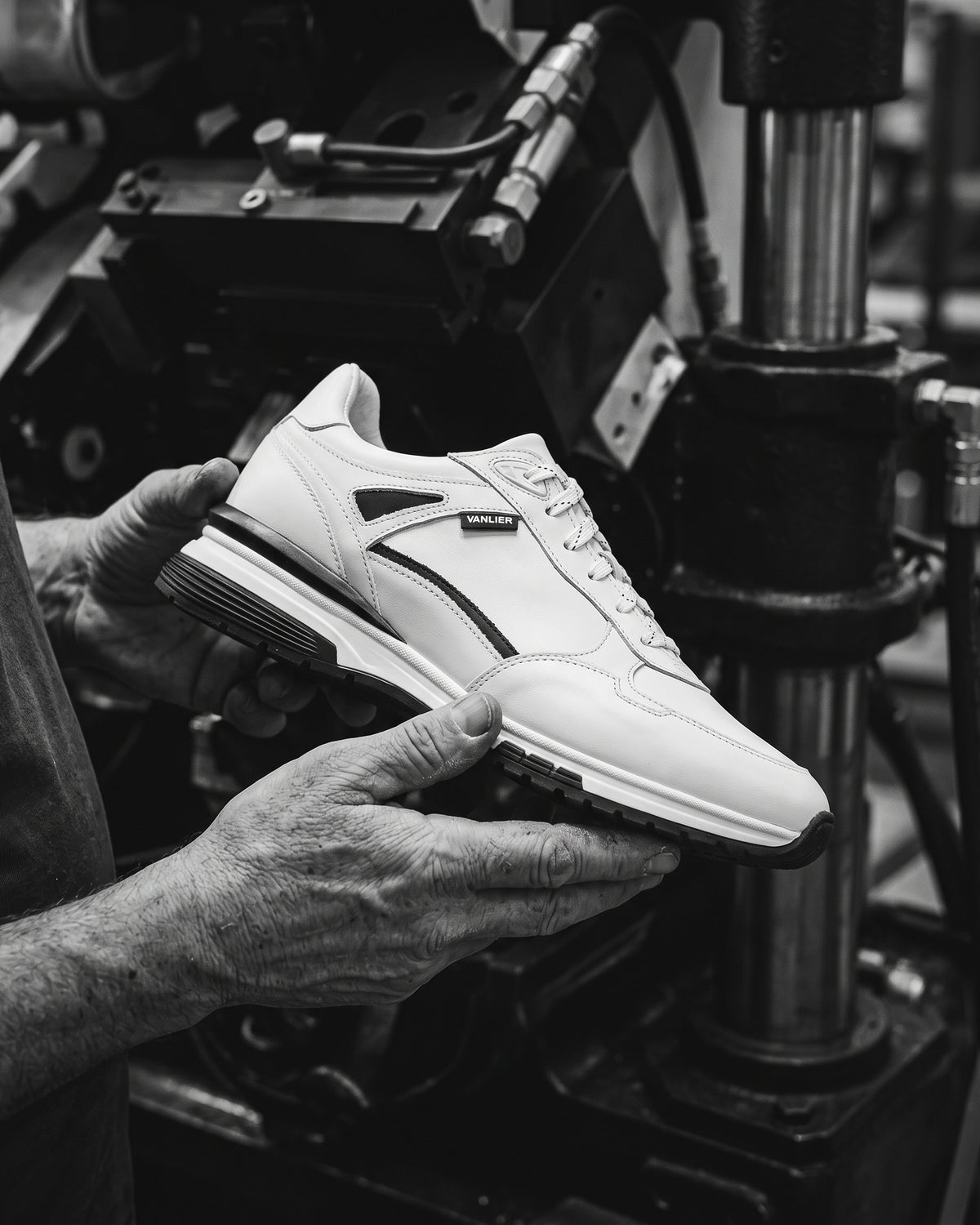Wit gladleren Veneto sneaker – vakmanschap, schoen vastgehouden in de werkplaats