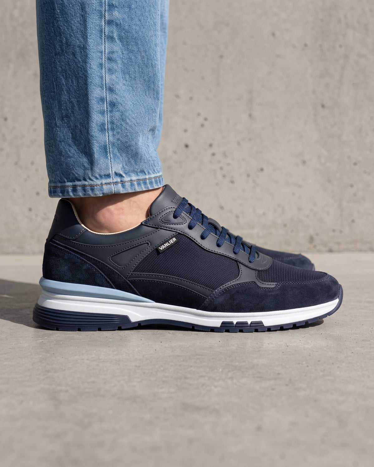 Blauw nubuck Veneto sneaker – close-up van het paar op een ruwe betonnen vloer