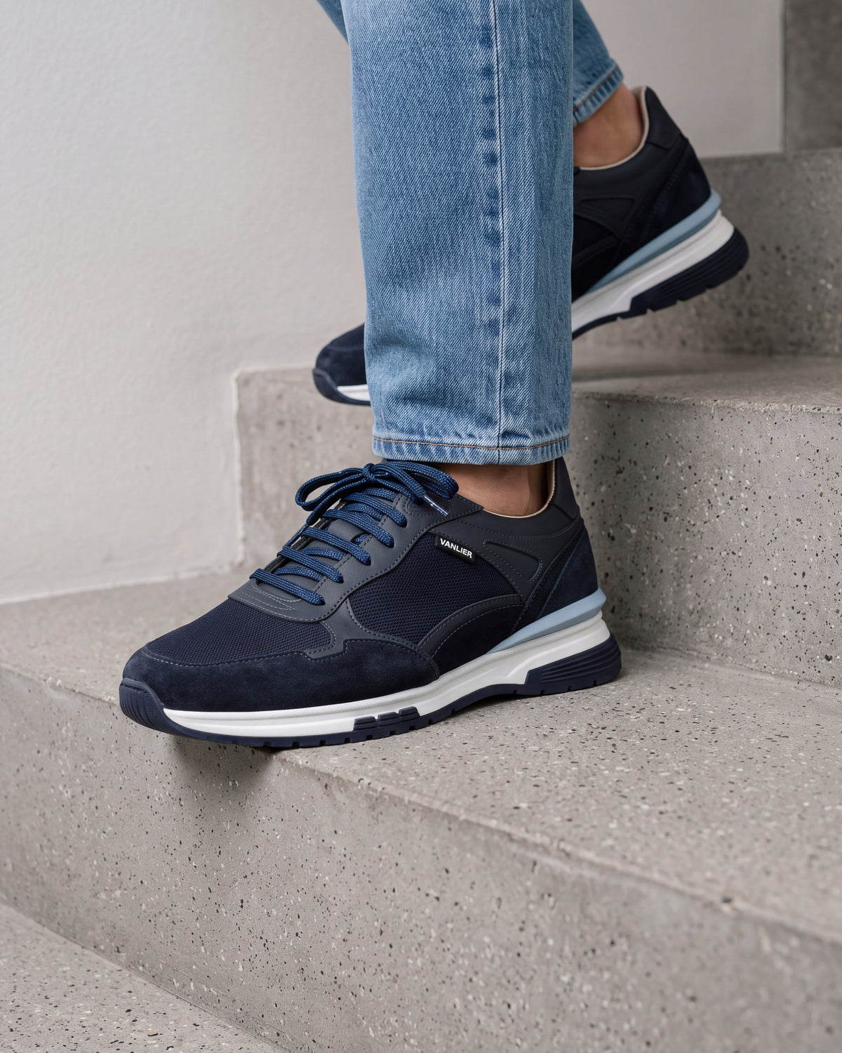 Blauw nubuck Veneto sneaker – close-up van het paar in een betonnen atelier