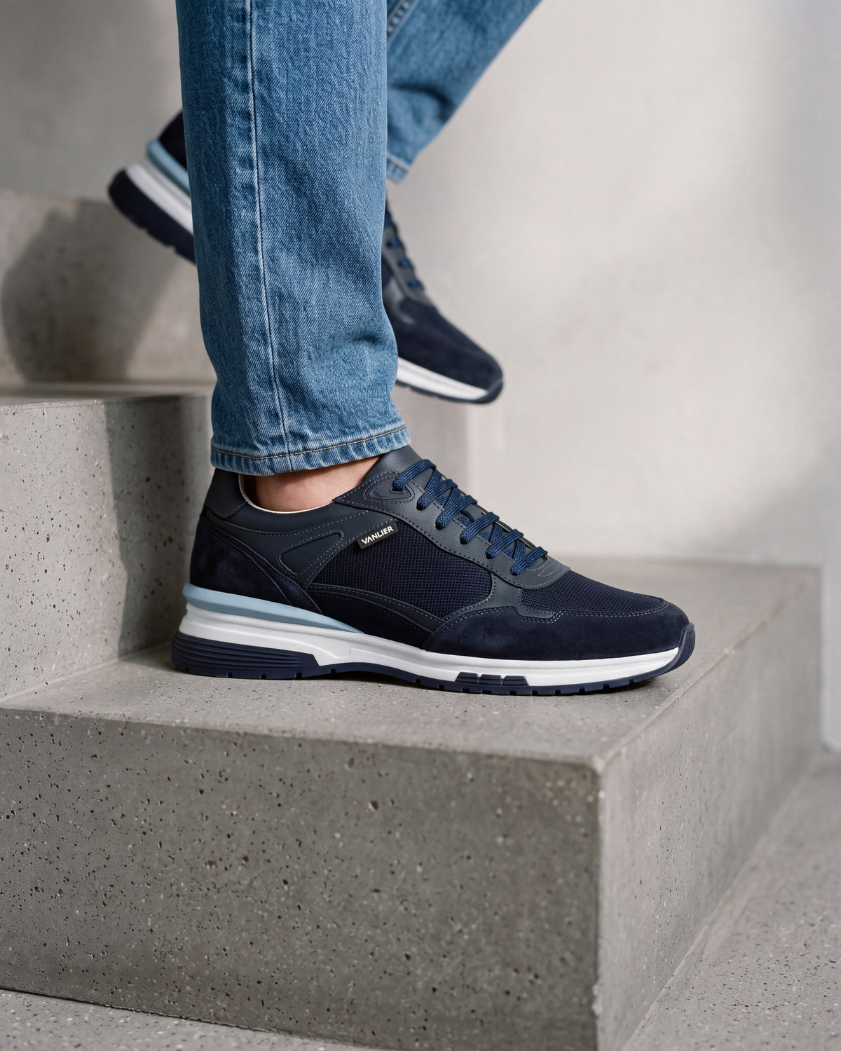 Blauw nubuck Veneto sneaker – close-up van het paar in een betonnen atelier