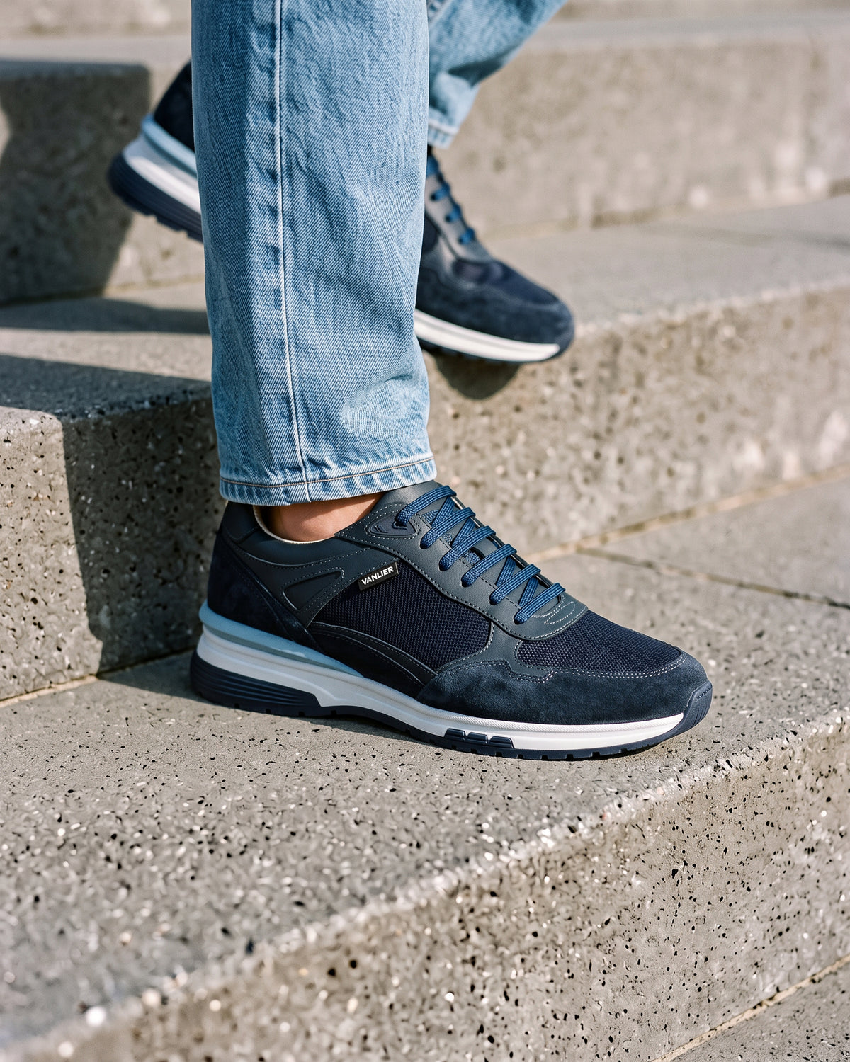 Blauw nubuck Veneto sneaker – close-up van het paar op een ruwe betonnen vloer
