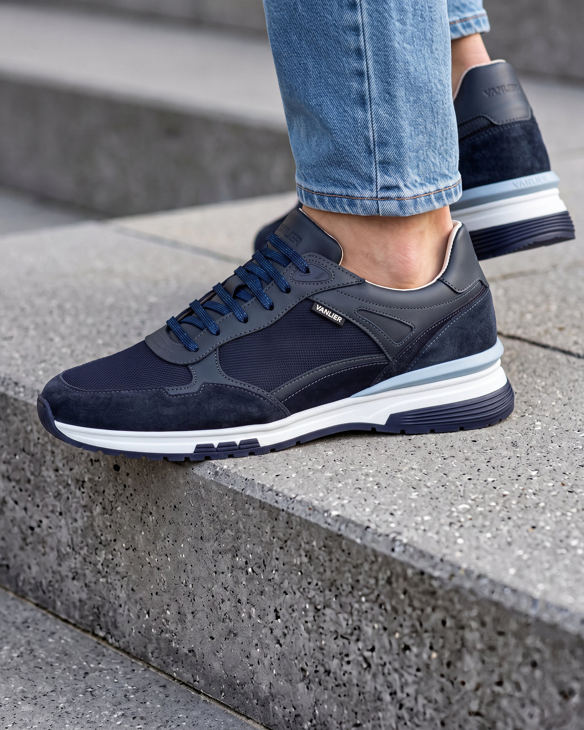 Blauw nubuck Veneto sneaker – close-up van het paar op een ruwe betonnen vloer