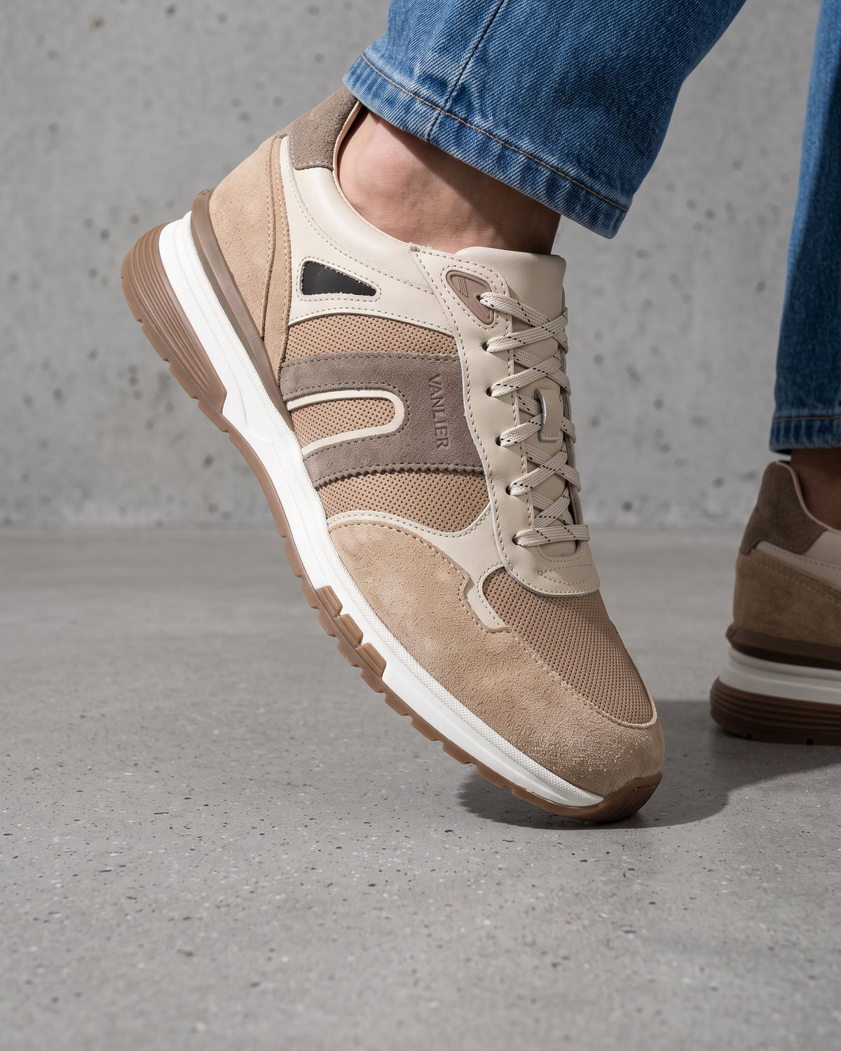 Taupe suède combi Veneto sneaker – close-up van het paar in een betonnen atelier