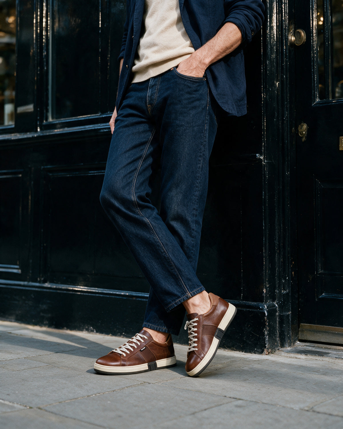 Cognac gladleren Retro sneaker – gedragen, leunend tegen een winkelpui