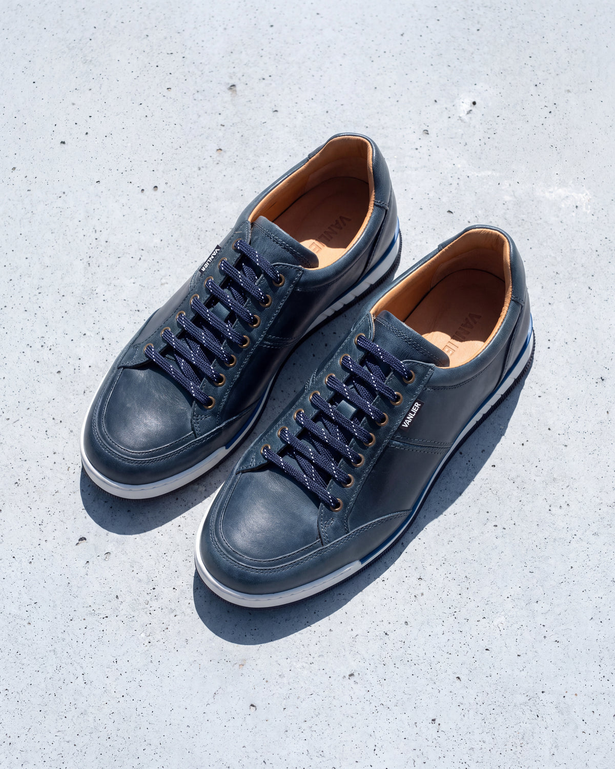 Blauw gladleren Magnus sneaker – paar op ruw beton, derde opname