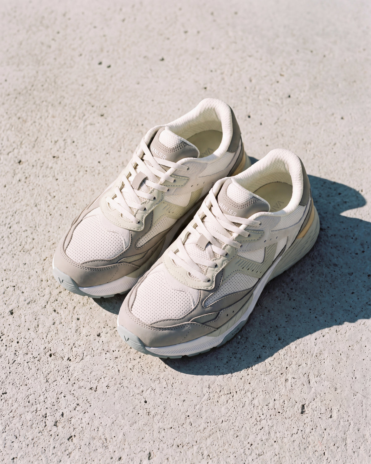 Wit lichtgroen combi Cosmos sneaker – close-up van het paar op ruw beton