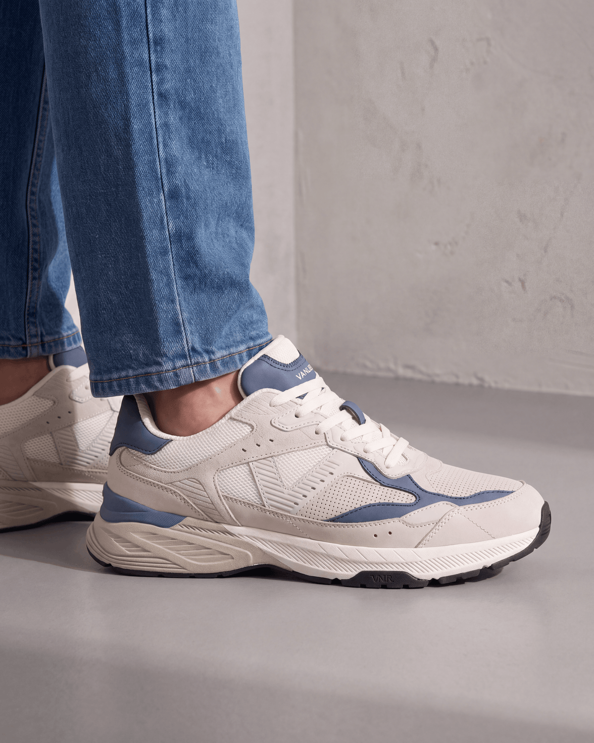 Wit lichtblauw combi Cosmos sneaker – gedragen, driekwart aanzicht op beton