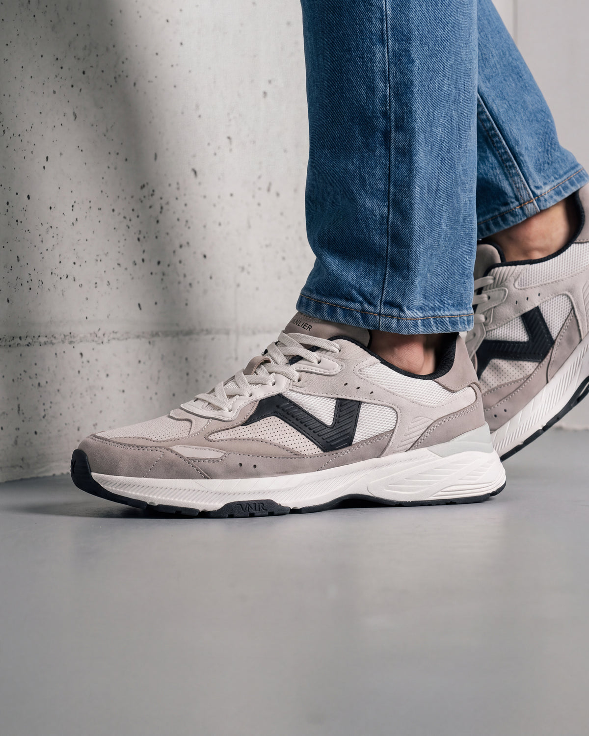 Wit zwart combi Cosmos sneaker – close-up van het paar in een betonnen atelier